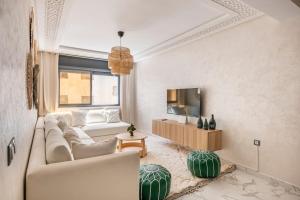 a living room with a couch and a tv at TT Holidays Cosy apartment Rabat City Center in Rabat