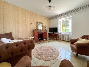 ein Wohnzimmer mit Couch und Kamin in der Unterkunft Maison Sainte-Sabine Castels in Castels