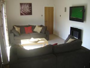 a living room with a couch and a tv at 10 Trehawks in Wadebridge