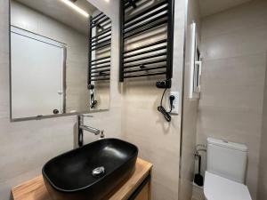 een badkamer met een zwarte wastafel en een toilet bij Superflat near beach 15' center in Sant Adria de Besos