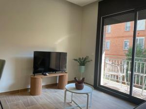 a living room with a flat screen tv and a window at Superflat near beach 15' center in Sant Adria de Besos