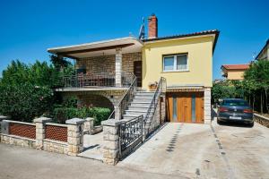 a yellow house with a gate and a driveway at Apartmani Erik Umag in Umag