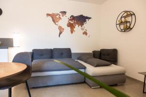 a couch with a map of the world on the wall at Merano City Living in Merano