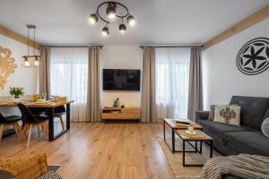 ein Wohnzimmer mit einem Sofa und einem Tisch in der Unterkunft ZakoApartament Brzozowa in Zakopane