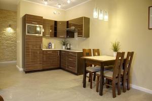 a kitchen with a wooden table and a table and chairs at Apartament 25 Panorama Gór in Szklarska Poręba