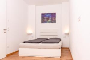 a bed in a room with white walls at Merano City Living in Merano