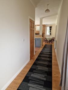 a hallway with a black and white rug on the floor at Country retreat near sea and South Downs, on National Cycle Network in Polegate