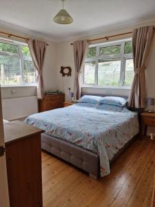 a bedroom with a bed and two windows at Country retreat near sea and South Downs, on National Cycle Network in Polegate