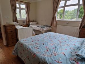 a bedroom with two beds and two windows at Country retreat near sea and South Downs, on National Cycle Network in Polegate