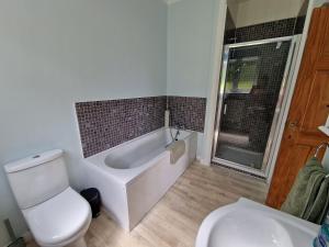 a bathroom with a tub and a toilet and a sink at Country retreat near sea and South Downs, on National Cycle Network in Polegate