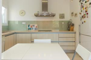 een keuken met een witte tafel en een koelkast bij Casa Rosselló in Sant Feliu de Guixols