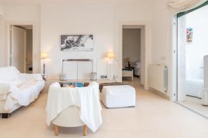 een witte kamer met een bed en een tafel bij Casa Rosselló in Sant Feliu de Guixols