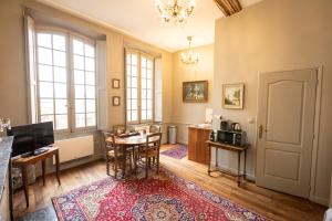 - un salon avec une table et une salle à manger dans l'établissement L'Hotel de Panette, chambres indépendantes - entrée sainte Chapelle, à Bourges