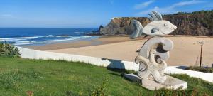 a statue of a rabbit on the beach at Sunset Room - Costa Vicentina in Odeceixe +31 photos