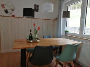 - une table à manger avec des chaises et une bouteille de vin dans l'établissement Ferienwohnung deine Rauszeit, à Seebach