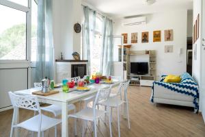ein Esszimmer mit einem weißen Tisch und Stühlen in der Unterkunft Villa Blanca - Villa intera con trullo e piscina in Putignano