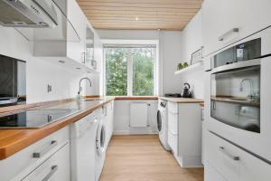 a white kitchen with a sink and a dishwasher at Cozy 2-Bed Apartment in Aalborg in Aalborg