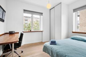 a bedroom with a desk and a bed and windows at Cozy 2-Bed Apartment in Aalborg in Aalborg
