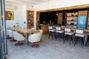 una sala da pranzo con tavolo e sgabelli in legno di Ali Baba Ciftligi Boutique Hotel ad Alaçatı