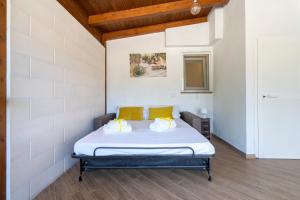 ein Schlafzimmer mit einem Bett mit gelben Kissen in der Unterkunft Villa Blanca - Villa intera con trullo e piscina in Putignano