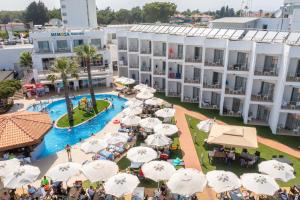 an aerial view of a hotel with a pool and umbrellas at Mimoza Beach Hotel in Yenibosazici