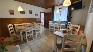 a dining room with white chairs and a table and a dining room at Friendly Home - Klinkerhof in Bornheim