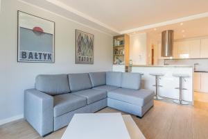 a living room with a couch and a kitchen at RentPlanet - Apartamenty Żeromskiego in Szklarska Poręba
