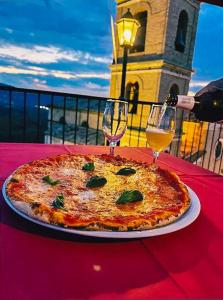 uma pizza sentada numa mesa com dois copos de vinho em Il Ghiro 2.0 Casa Vacanze em San Martino sulla Marruccina