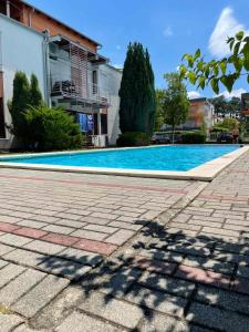 a swimming pool in front of a house at Gold Sea Apartman in Siófok