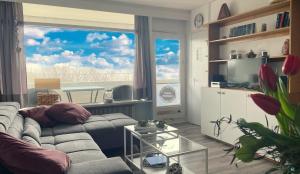 uma sala de estar com um sofá e uma grande janela em Panoramic App A05-2 em Sierksdorf