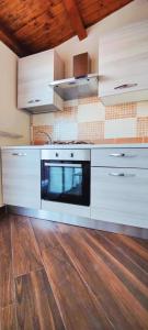 a kitchen with white appliances and a wooden floor at SantOliva Apartments in Trabia