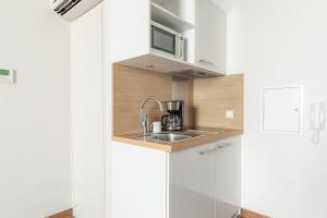 Una pequeña cocina con fregadero y microondas. en Appart'City Confort Bordeaux Chartrons, en Burdeos