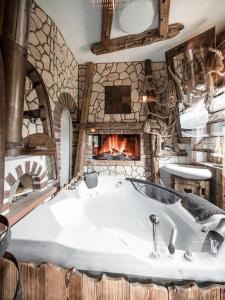 a bathroom with a large tub and a fireplace at Romantik-Suite - Nationalpark Kalkalpen in Ramsau