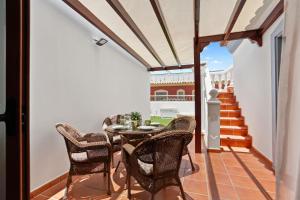 a dining room with a table and chairs on a balcony at Villa Thomas in Corralejo