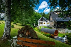 a wooden bench sitting in front of a house at Dom Stary Młyn nad strumieniem z możliwością dostępu do sauny, gorącej beczki, basenem in Szklarska Poręba