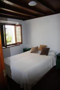 1 dormitorio con 1 cama blanca grande y 2 ventanas en Tazones Asturias Casa de pescadores, en Tazones