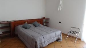 1 dormitorio con 1 cama y 1 silla en ai18diamanti, en Saludecio