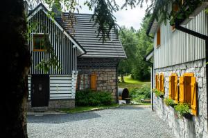 ein Haus mit gelben Fensterläden und einem Steingebäude in der Unterkunft Dom Stary Młyn nad strumieniem z dostępem do sauny, gorącej beczki, basenem in Szklarska Poręba