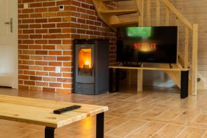 a living room with a tv and a fireplace at Dom Stary Młyn nad strumieniem z możliwością dostępu do sauny, gorącej beczki, basenem in Szklarska Poręba