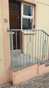 a metal railing in front of a door at Lower Main Street Apartment in Letterkenny