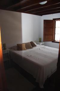 a bedroom with a white bed and a window at Tazones Asturias Casa de pescadores in Tazones