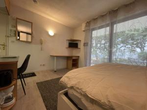 1 dormitorio con cama, escritorio y ventana en Appartement La Rochelle, 1 pièce, 2 personnes - FR-1-246-121, en La Rochelle