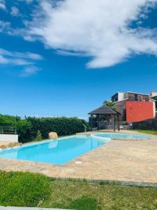 een groot blauw zwembad met een prieel bij LE LAGON La Saline Les Bains vue mer, piscine in La Saline les Bains