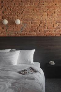a bedroom with a brick wall and a bed at Resume apartments in Kaunas
