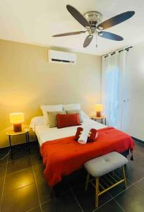 een slaapkamer met een bed met een plafondventilator bij LE LAGON La Saline Les Bains vue mer, piscine in La Saline les Bains