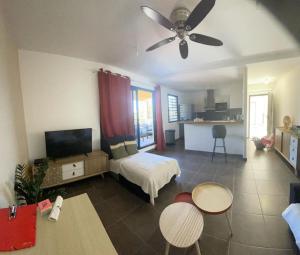 een woonkamer met een bed en een plafondventilator bij LE LAGON La Saline Les Bains vue mer, piscine in La Saline les Bains