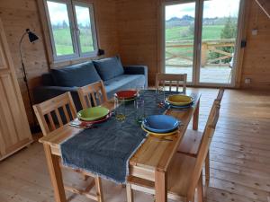 jadalnia ze stołem, krzesłami i kanapą w obiekcie Bieszczadzka Polana - domki turystyczne/sezonowe w mieście Lutowiska