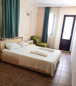a hotel room with a bed and a chair at Golden Beach Hotel in Didim