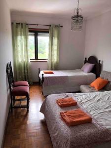 - une chambre avec deux lits, une chaise et une fenêtre dans l'établissement Lovely 2 bedroom apartment 100m from the beach, à Vila do Conde