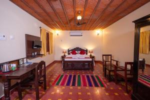 a bedroom with a bed and a table and chairs at CHETTINAD HERITAGE WELLNESS RESORTS in Mithilaipatti